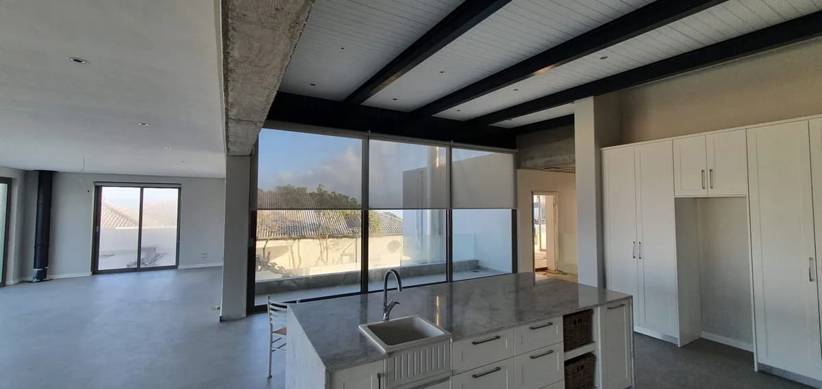 Transparent roller blinds in a modern open-plan kitchen