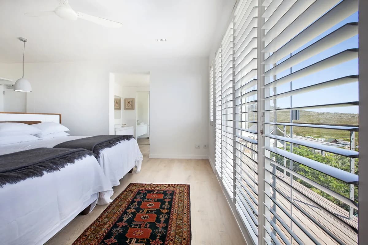Aluminium hurricane shutters open onto a balcony with a mountain view