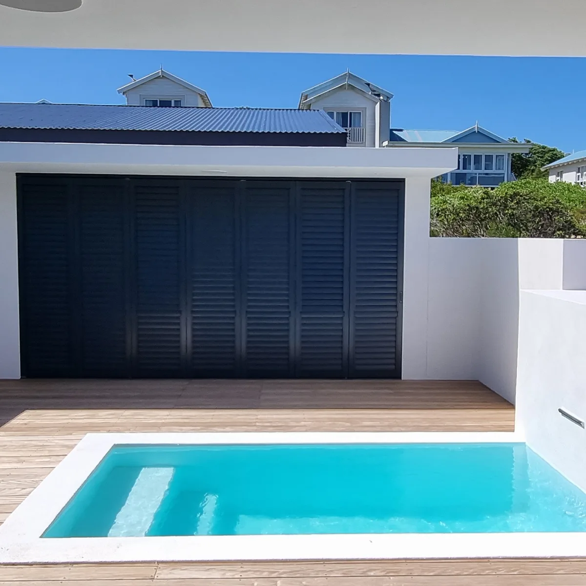 Aluminium hurricane shutters beside a pool deck in Blouberg