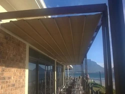 Retractable patioshade awning over a pergola with an ocean view